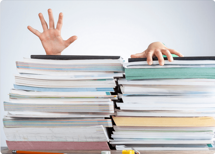 A pile of books with hands showing at the top